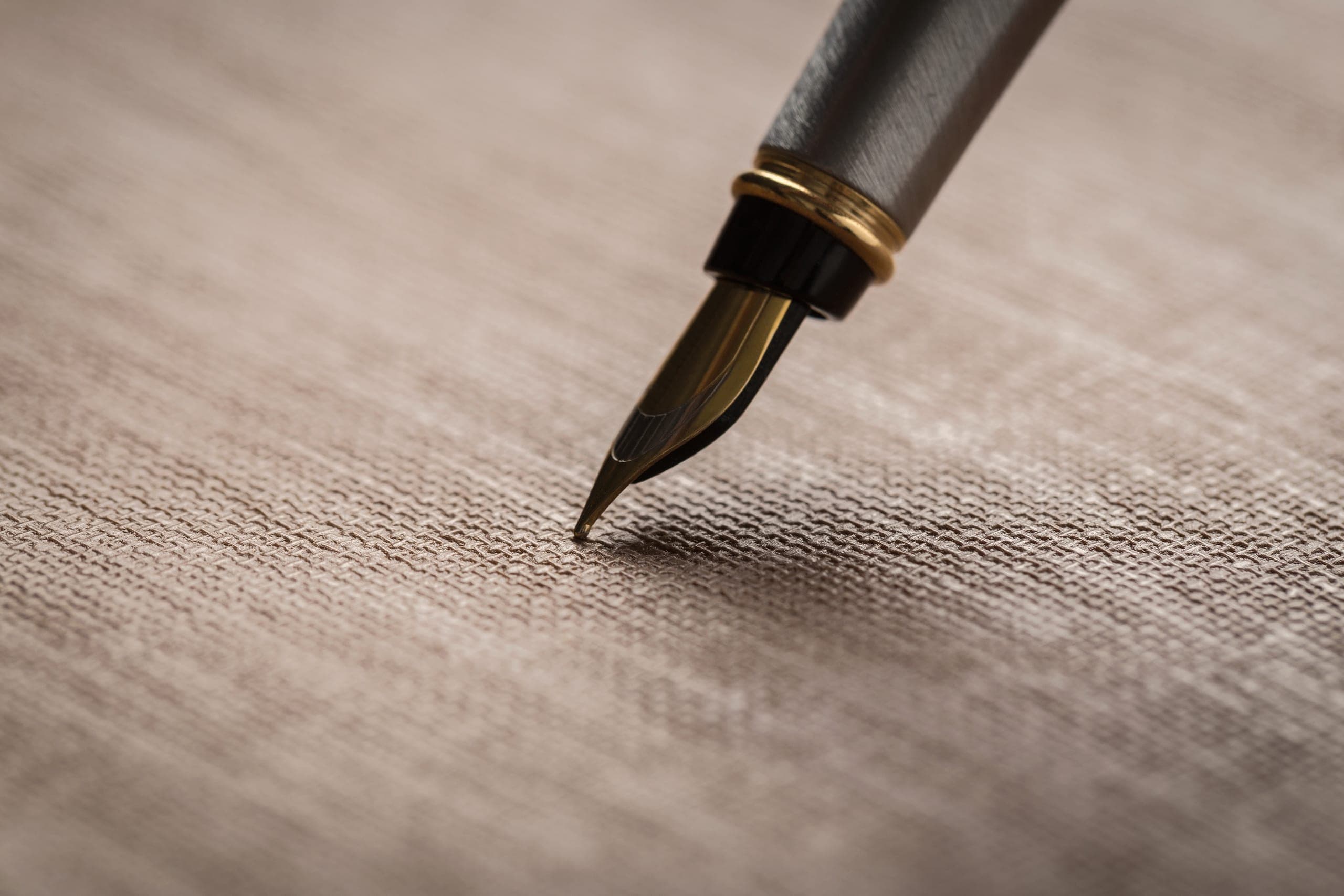 The nib of a fountain pen resting on linen