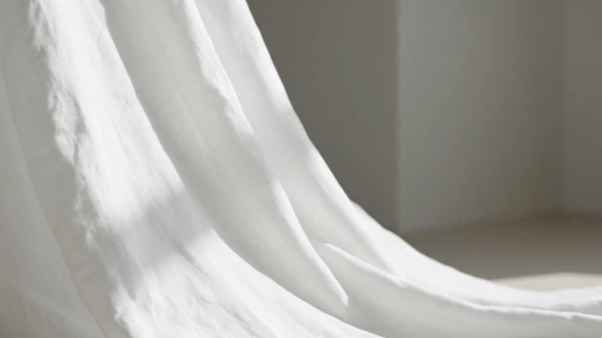 White linen falling in soft light in a quiet room